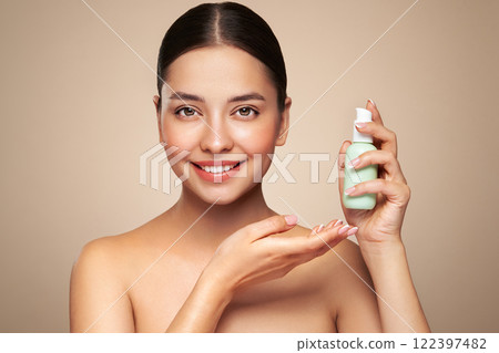 Beautiful woman with bottle of moisturizer cream Beautiful woman with bottle of moisturizer cream 122397482