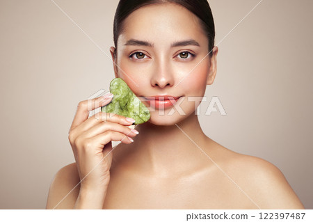 Young woman doing scrapping massage facial skin 122397487