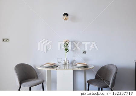A modern minimalist dining table set featuring a charming floral centerpiece for decor 122397717
