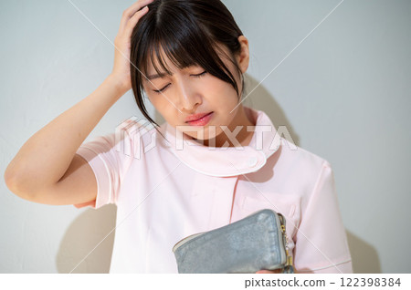 Japanese clinic staff looking at their wallets and worrying 122398384