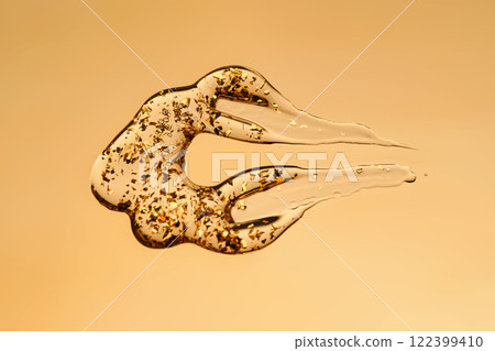 A delicious drop of 24k gold serum on a gold background. 122399410
