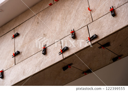 Tile leveling system with plastic clips and wedges, shot while the tile mortar sets. Tile leveling system with plastic clips and wedges, shot while the tile mortar sets. 122399555