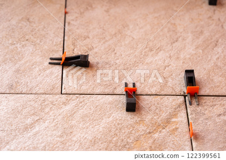 Tile leveling system with plastic clips and wedges, shot while the tile mortar sets. Tile leveling system with plastic clips and wedges, shot while the tile mortar sets. 122399561