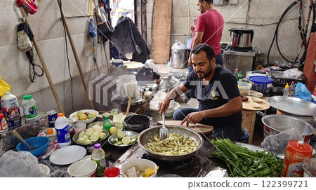 Experience the vibrant atmosphere of candid street cooking in a busy and bustling kitchen Experience the vibrant atmosphere of candid street cooking in a busy and bustling kitchen 122399721