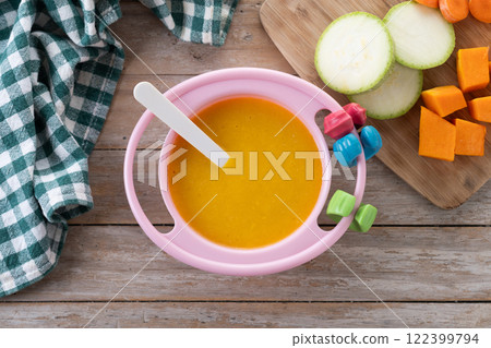 Bowl with baby food. vegetable puree on wooden table 122399794