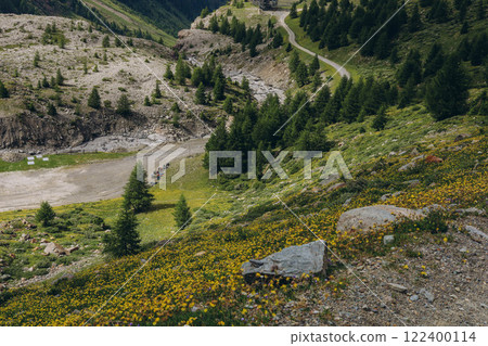 A scenic view of rolling green hills and distant mountains in the Alps Mountains A scenic view of rolling green hills and distant mountains in the Alps Mountains 122400114