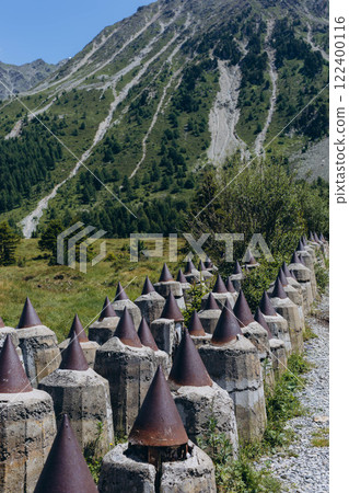 Border between Austria Tyrol and Italy South Tyrol at Passo Resia with dragon's teeth tank barrier 122400116