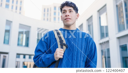 Young college student walking on university campus looking up at the sky 122400407