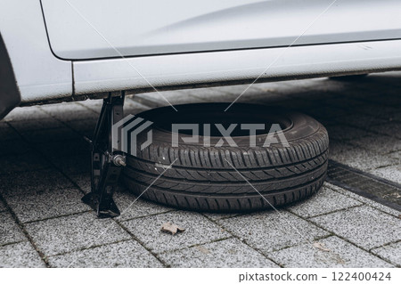 Emergency situation with a car, replacing a tire on the roadside 122400424