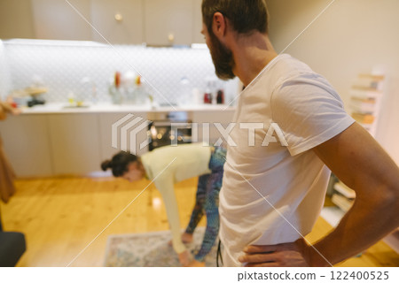 A couple joyfully interacts in their modern kitchen, highlighting their love for cooking 122400525