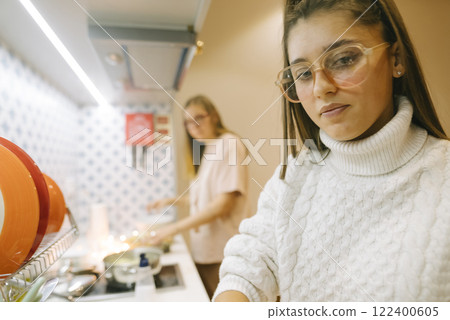 A group of friends joyfully cooking together in a modern, stylish kitchen space 122400605