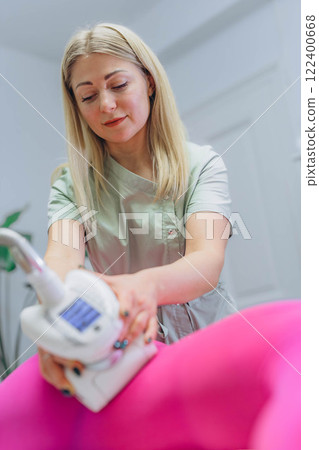 The masseur is preparing to make an hardware anti-cellulite massage in a beauty salon. 122400668