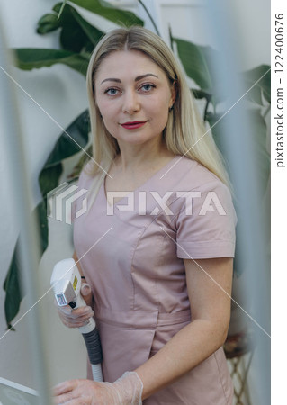 young woman master of laser hair removal, laser apart, woman smiles,Cosmetology section hair removal 122400676