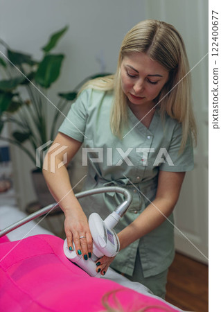 Lpg massage procedure. Hands of therapist holding lipomassage tool. Close up, selective focus. 122400677
