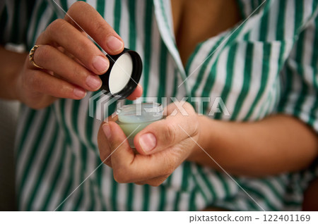 Hands Opening A Small Jar of Skincare Cream in A Relaxed Setting Hands Opening A Small Jar of Skincare Cream in A Relaxed Setting 122401169