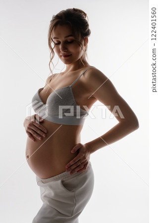 Beautiful pregnant woman in lingerie showcasing her baby bump Beautiful pregnant woman in lingerie showcasing her baby bump 122401560