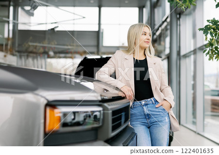 Business woman leaning on new pickup truck in car dealership showroom 122401635