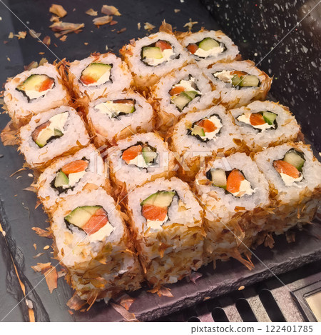 Delightful sushi rolls arranged in a beautiful presentation on a dark slate Delightful sushi rolls arranged in a beautiful presentation on a dark slate 122401785