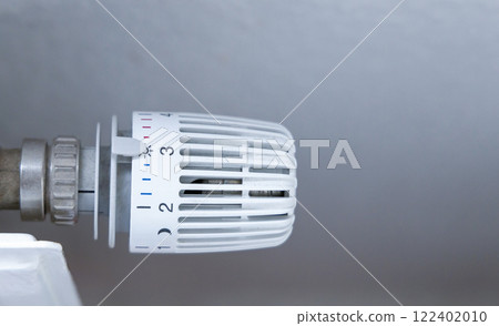 Heating battery temperature regulation in house with thermostat on white radiator. 122402010