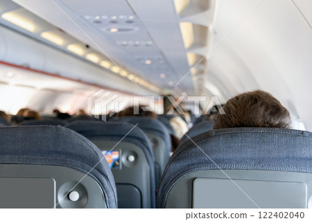 Inside the passenger plane cabin with people. 122402040