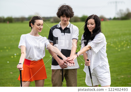 Young golfers standing on a golf field with brassies in hands Young golfers standing on a golf field with brassies in hands 122402493