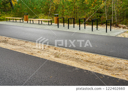 Contemporary ecological seaside environmental development, bike path, wooden benches, trash can 122402660