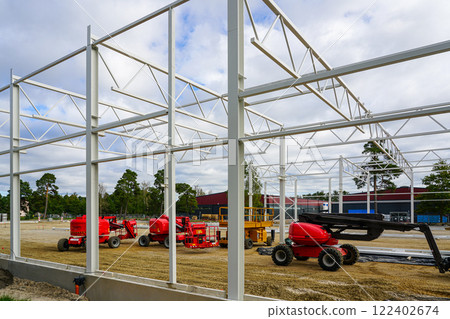 Modern self propelled construction hydraulic lifts on modern metal frame building construction site Modern self propelled construction hydraulic lifts on modern metal frame building construction site 122402674