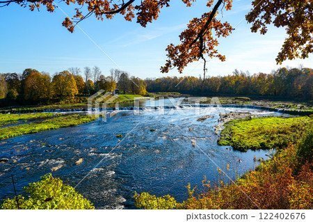 Colorful, picturesque autumn view of the widest European waterfall on the Venta River in Latvia 122402676