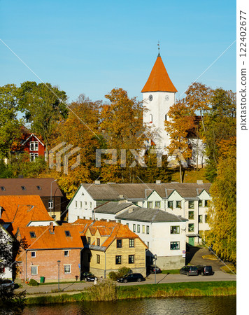 Beautiful view of Talsi Old Town with a white church tower and trees in autumn colors with blue sky 122402677