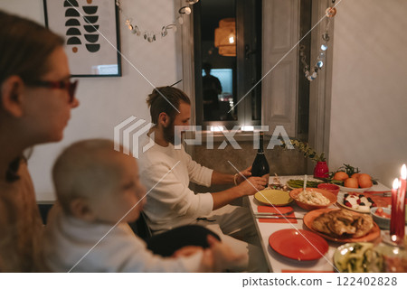 Experience a Cozy Family Dinner Celebration with a Warm Candlelit Atmosphere and Joyful Vibes Experience a Cozy Family Dinner Celebration with a Warm Candlelit Atmosphere and Joyful Vibes 122402828
