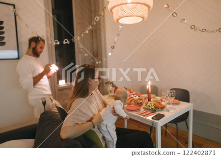 Enjoying a Cozy Family Dinner Celebration with a Baby in Beautiful Modern Decor Themes Enjoying a Cozy Family Dinner Celebration with a Baby in Beautiful Modern Decor Themes 122402871