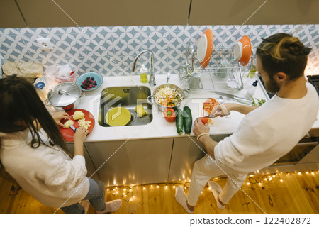 A happy couple is joyfully cooking together in their cozy and inviting kitchen space A happy couple is joyfully cooking together in their cozy and inviting kitchen space 122402872