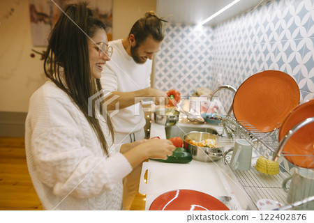 A couple cooks in a colorful kitchen, highlighting their love for food and collaboration 122402876