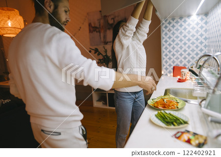 A Couple Enjoying Cooking Together in a Modern Kitchen Setting, Creating Delicious Meals 122402921