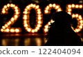 A striking silhouette is set against the bright, illuminated numbers for the year 2025 122404094