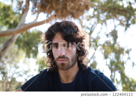 Pensive Long Hair Man Sitting On The Sidewalk Reflecting On Debts 122404113