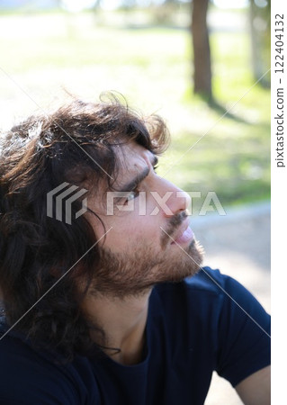 Pensive Long Hair Man Sitting On The Sidewalk Reflecting On Debts 122404132