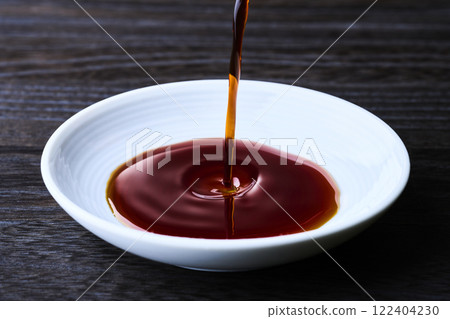 將醬油倒入小盤子中 將醬油倒入小盤子中 122404230