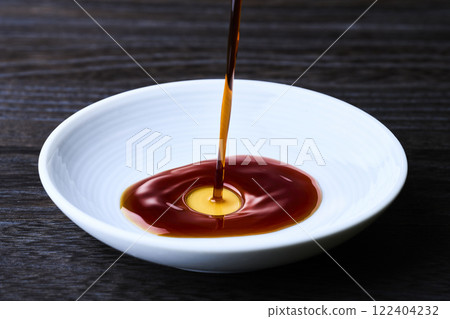 將醬油倒入小盤子中 將醬油倒入小盤子中 122404232