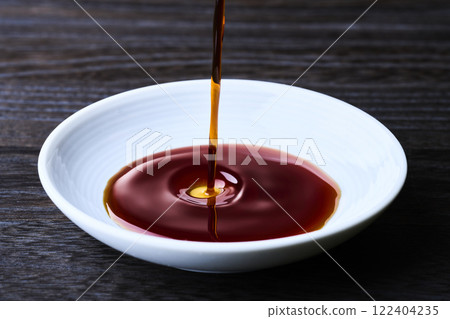將醬油倒入小盤子中 將醬油倒入小盤子中 122404235