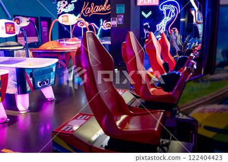 Gaming chairs in illuminated arcade game zone in 122404423