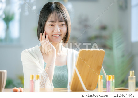 A young woman feels her skin become more moisturized 122404443