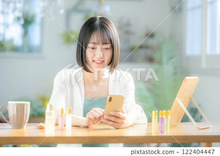 A young woman operating a smartphone A young woman operating a smartphone 122404447