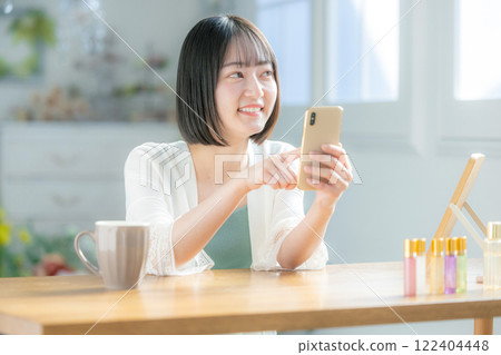 A young woman operating a smartphone A young woman operating a smartphone 122404448
