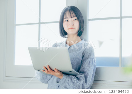 使用個人計算機的一個少婦在屋子裡 122404453