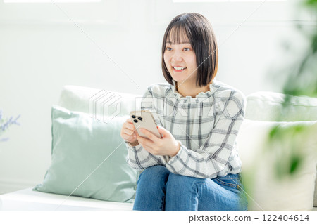 年輕女子用智慧型手機在沙發上放鬆 122404614