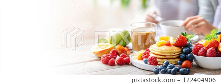 Family enjoys a bright morning breakfast together with fresh fruit and pancakes 122404906