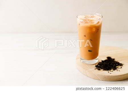 Iced Thai milk tea in a glass on wooden table. 122406625