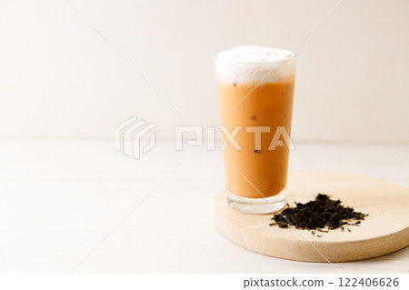 Iced Thai milk tea in a glass on wooden table. 122406626