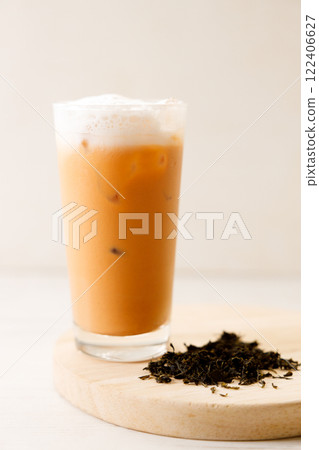 Iced Thai milk tea in a glass on wooden table. 122406627